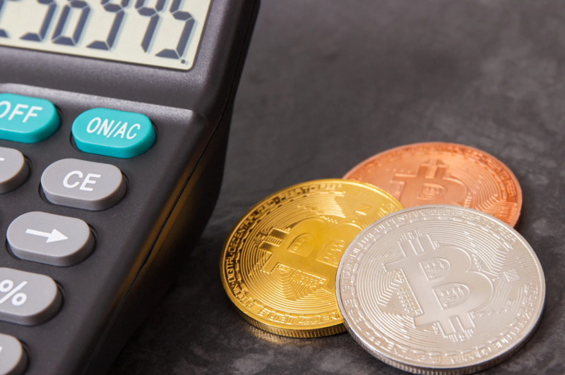 Calculator next to cryptocurrency coins
